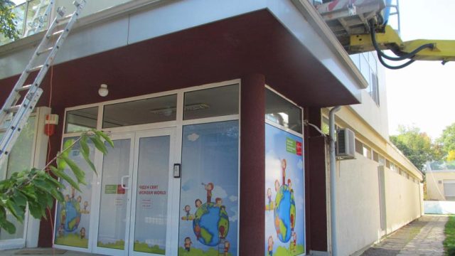 Витрини на магазин, облепени с цветно рекламно фолио